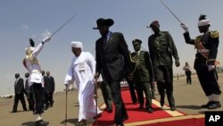South Sudanese President Salva Kiir, center, walks with Sudanese counterpart Omar al-Bashir, Khartoum, Oct. 2011 (file photo).