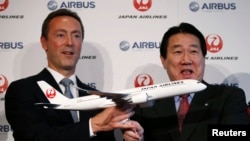 Pimpinan Japan Airlines Yoshiharu Ueki (kanan) and Pimpinan Eksekutif Airbus Fabrice Bregier berpose dengan model pesawat Airbus A350 dalam konferensi pers di Tokyo (7/10).