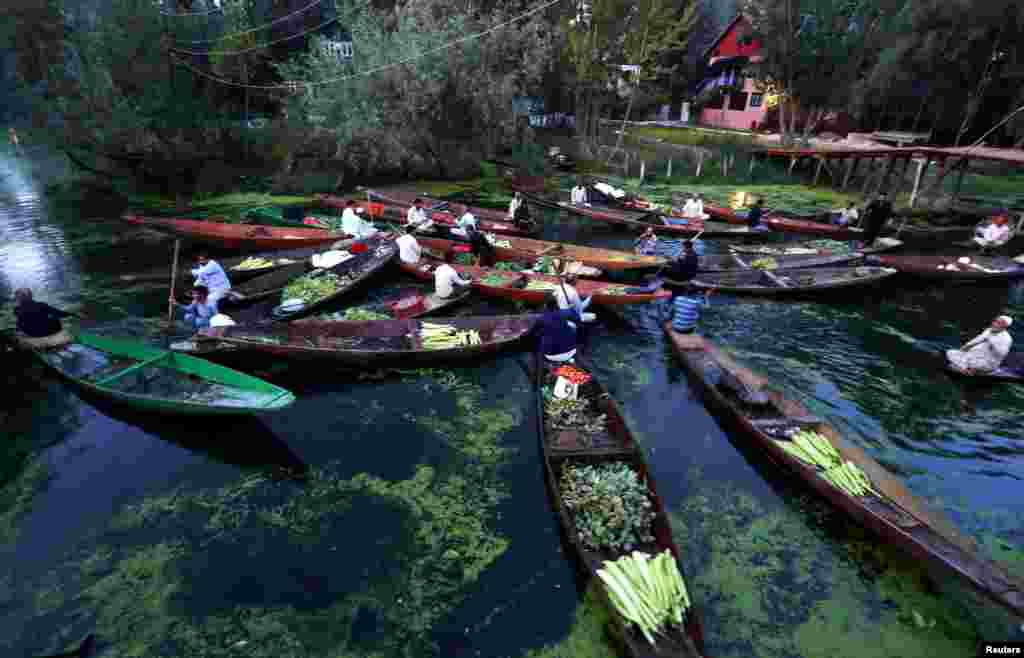 Vegetable vendors assemble at a floating market on Dal Lake during restrictions in Srinagar, India-controlled Kashmir.
