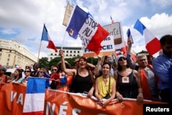 Protesters attend a demonstration called by the French nationalist party "Les Patriotes" against restrictions, including a compulsory health pass, to fight COVID-19 outside the Ministry of Health in Paris, France, July 31, 2021.