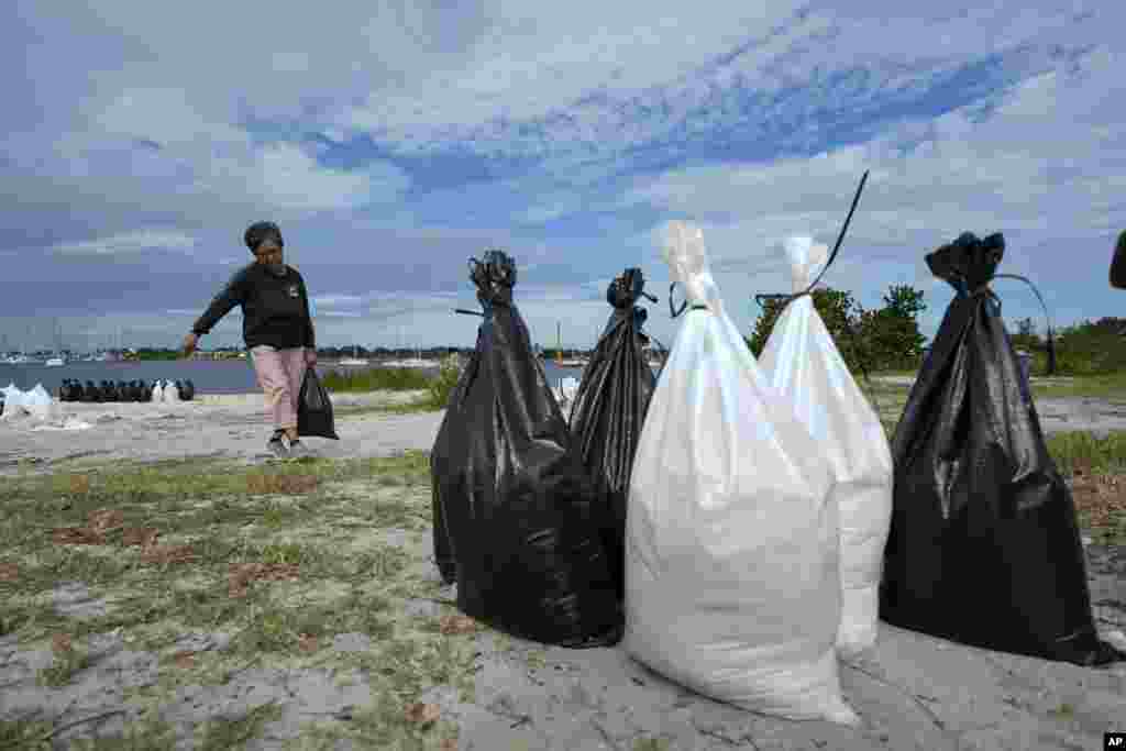 Susana Ortiz fills out sand bags on the beach at the Davis Islands Yacht Basin as she prepares for the arrival of Hurricane Milton, Oct. 8, 2024, in Tampa, Florida.