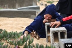 FILE—A woman cries over the grave of a loved one at the start of the Eid al-Fitr festival, marking the end of the Muslim holy month of Ramadan, at a cemetary in Rafah in the southern Gaza Strip, on April 10, 2024, amid the ongoing conflict between Israel and Hamas.