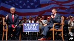 FILE - Republican presidential candidate Donald Trump gives a thumbs up as he speaks with retired Lt. Gen. Michael Flynn during a town hall in Virginia Beach, Va., Sept. 6, 2016.