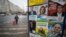 FILE - People pass by a billboard displaying posters for various candidates in the parliamentary elections, in Bucharest, Dec. 3, 2020.