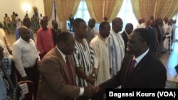 Le président de la transition au Burkina, Michel Kafando, salue les signataires de la Charte au Burkina lors de la réunion devant fixer la nouvelle date des élections dans le pays, 13 octobre 2015. (VOA/Bagassi Koura)