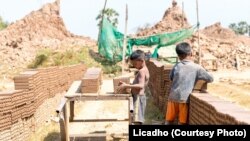 Two boys were placing bricks on a wooden cart at a brick factory in Cambodia. (Courtesy photo of Licadho)