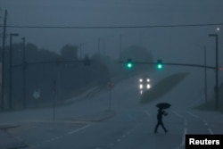 A antheral   walks down   an avenue arsenic  Hurricane Milton approaches Orlando, Florida, Oct. 9, 2024.