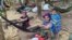 In this photo released by the Free Burma Rangers, ethnic Karen women sit with family members in the jungles of northern Karen State where they are sheltering from an ongoing local offensive by the Myanmar army, on Jan. 27. (Free Burma Rangers via AP)
