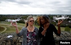 Aktivis Valerie Milner-Brown dan Linda Davidsen berpose dengan drone mereka dekat bandara Heathrow, London, Inggris, 12 September 2019.