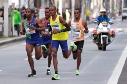 Ethiopea's Birhanu Legese, right, races with other runners on his way to winning the Tokyo Marathon in Tokyo, Japan, March 1, 2020.