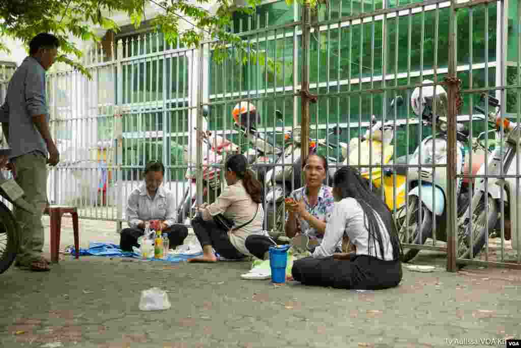 ឪពុកម្តាយហូបអាហារថ្ងៃត្រង់ជាមួយកូននៅក្បែរមណ្ឌលប្រឡង នៅរាជធានីភ្នំពេញ ថ្ងៃចន្ទ ទី២០ ខែសីហា ឆ្នាំ២០១៨។ (ទី អូលីស្សា/VOA)