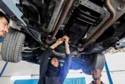 Huda al-Matroushi sedang memperbaiki mobil bersama karyawannya di bengkelnya di Sharjah, Uni Emirat Arab, 21 April 2021. (Foto: Rula Rouhana/Reuters)