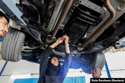 Huda al-Matroushi sedang memperbaiki mobil bersama karyawannya di bengkelnya di Sharjah, Uni Emirat Arab, 21 April 2021. (Foto: Rula Rouhana/Reuters)