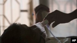 ARCHIVO - Un familiar ajusta la máscara de oxígeno de un paciente con tuberculosis en un hospital de tuberculosis en el Día Mundial de la Tuberculosis en Hyderabad, India, el 24 de marzo de 2018.