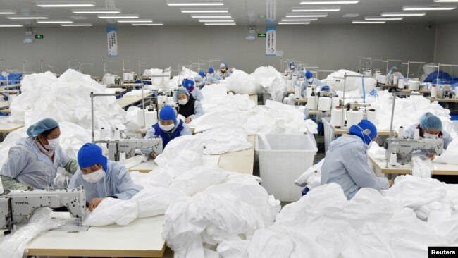 中国安徽省巢湖一家工厂的工人为抗击新冠病毒疫情在赶制防护服。（2020年1月28日）