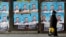 People walk next to posters of the candidates for the early parliamentary elections in Skopje, Macedonia, Dec. 8, 2016. 