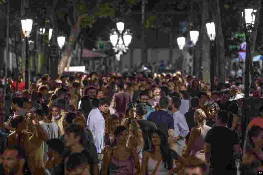 People gather in a popular party area in downtown Barcelona, Spain.