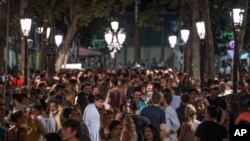 People gather in a popular party area in downtown Barcelona, Spain, early Sunday, July 4, 2021.