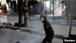 Palestinian protester uses a sling to hurl stones at Israeli troops during clashes in the West Bank city of Hebron Feb. 2, 2018.