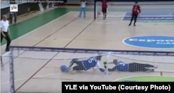 Screen grab from the YLE broadcast of the women’s gold medal match at the 2014 IBSA Goalball World Championships in Espoo, Finland. The first throw by Asya Miller (in red) scored a goal that led to victory over Russia.