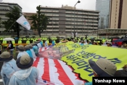 15일 서울 시청광장에서 열린 주권회복과 한반도 평화실현 8·15 범국민대회 참가자들이 사드 배치 반대 등을 주장하며 미국 대사관 앞 도로를 행진하고 있다.