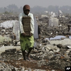 A resident collects bricks near houses flooded by mud flows from a volcano in Porong, East Java Province May 29, 2009.