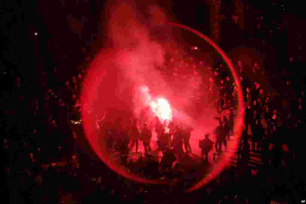 Catalan pro-independence demonstrators and Barcelona supporters light flares as they gather outside the Camp Nou stadium ahead of a Spanish La Liga soccer match between Barcelona and Real Madrid in Barcelona, Spain.