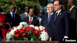 Le présdient français François Hollande (à droite), le vice-ministre des Anciens combattants et de la Défense Jean-Marc Todeschini (2e à droite) rendent hommage à Léopold Sédar Senghor, ancien président du Sénégal, au cimetière Bel Air, près de Dakar, 29 