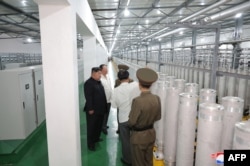 Pemimpin Korea Utara Kim Jong Un (kiri) sedang medninjau Institut Senjata Nuklir dan pangkalan produksi bahan nuklir kelas senjata, di lokasi yang dirahasiakan di Korea Utara, dalam foto yang dirilis 13 September 2024. (KCNA VIA KNS/AFP)