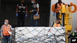 Trabajadores descargan un cargamento de la vacuna rusa COVID-19 Sputnik V, en el Aeropuerto Internacional Simón Bolívar de Maiquetía, Venezuela. Febrero 13, 2021. Foto: AP.