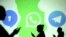 FILE - Silhouettes of mobile users are seen next to logos of social media apps Signal, Whatsapp and Telegram projected on a screen in this picture illustration.