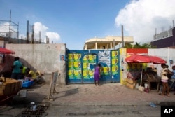 A woman tries to enter a school that will be used as a voting center for the upcoming elections, in Port-au-Prince, Haiti, Nov. 17, 2016. The U.S. Embassy applauded “significant steps” taken by Haiti following Hurricane Matthew to ensure that elections will be held, scheduled for Sunday.