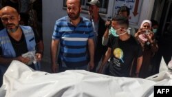 One of the bodies of staff members of the US-based aid group World Central Kitchen, is transported out of a hospital morgue in Rafah in the southern Gaza Strip on April 3, 2024, two days after a convoy of the NGO was hit in an Israeli strike as battles co