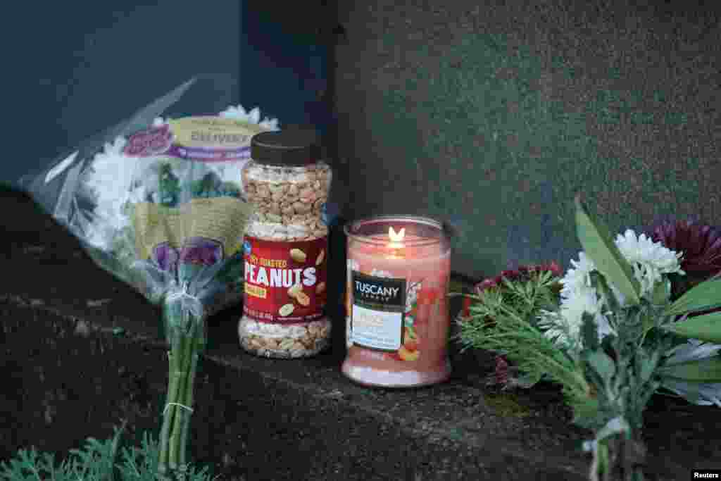 Flowers, peanuts and a candle lie by The Carter Presidential Center's sign, after the death of former U.S. President Jimmy Carter at the age of 100, in Atlanta, Georgia, Dec. 29, 2024. 