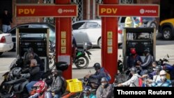 Motorizdos recargan gasolina en una gasolinera en San Antonio, Venezuela. Foto de archivo.