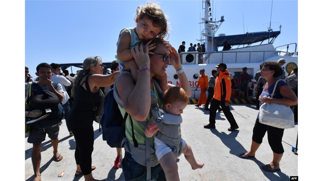 Para wisatawan mancanegara yang dievakuasi dari Pulau Gili Trawangan tiga di pelabuhan di Bangsal, utara Lombok, Selasa, 7 Agustus 2018, dua hari setelah wilayah tersebut diguncang gempa.(Foto:AFP)