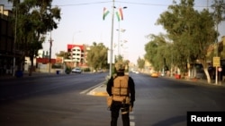 FILE - An Iraqi trooper stands guard on a street in Kirkuk, Iraq, Sept. 25, 2017. 