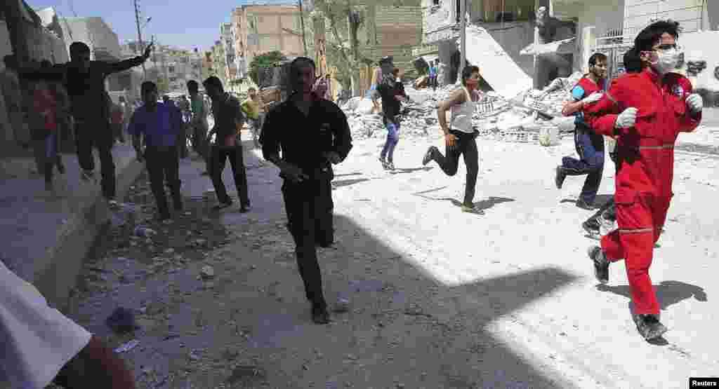 People run for cover after what activists said was shelling by forces loyal to Syria's President Bashar al-Assad in Raqqa province, eastern Syria, June 10, 2013. 