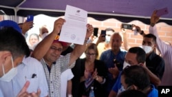 El gobernador electo del estado de Barinas, Sergio Garrido, muestra su certificado de ganador del consejo electoral regional el día después de las elecciones en Barinas, Venezuela, el 10 de enero de 2022