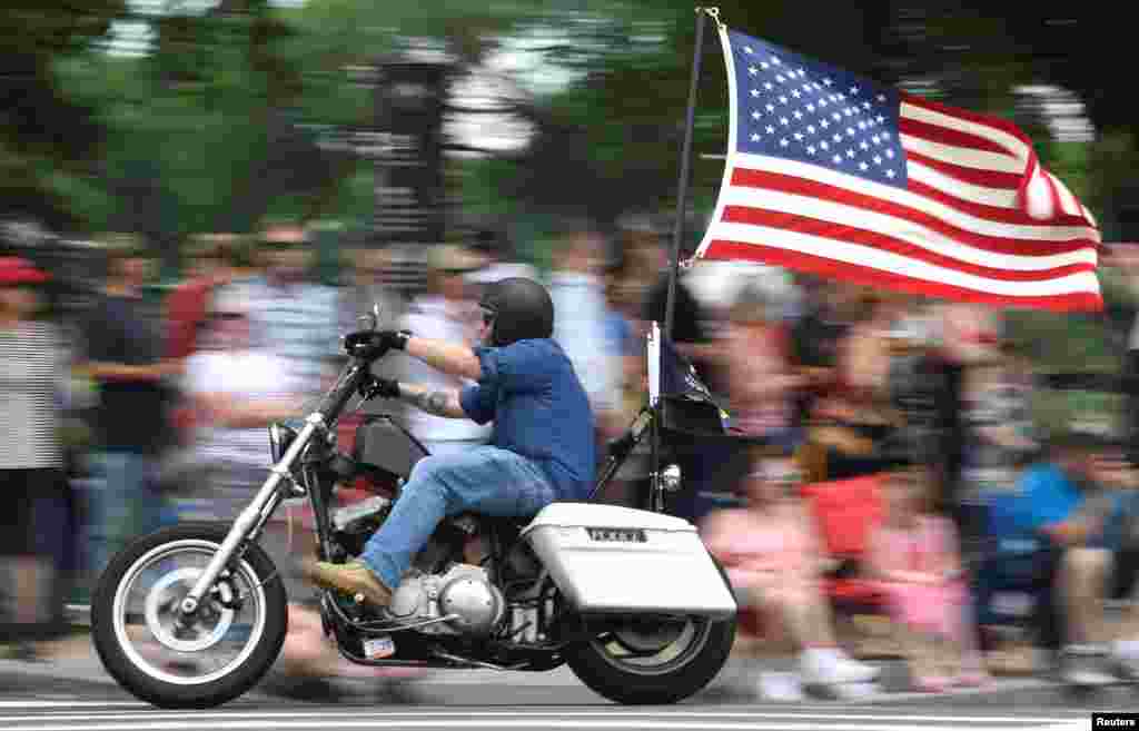 A motorcycle rider with American flag fluttering passes crowds during the 32nd Annual, and possibly final, Rolling Thunder &quot;Ride for Freedom&quot; during Memorial Day weekend to support veterans and call attention to POWs and MIAs, in Washington, D.C., May 26, 2019.