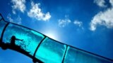 The silhouette of a child is visible in a water slide at an open air swimming pool in Mainz, Germany.