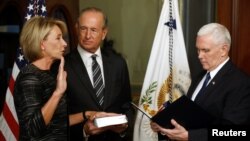 Vice President Mike Pence swears in Betsy DeVos as U.S. education secretary at the Eisenhower Executive Office Building at the White House in Washington, Feb. 7, 2017. With them is DeVos' husband, Dick DeVos.