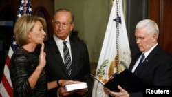 Vice President Mike Pence swears in Betsy DeVos as U.S. education secretary at the Eisenhower Executive Office Building at the White House in Washington, Feb. 7, 2017. With them is DeVos' husband, Dick DeVos. 