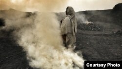 A woman tends fires of burning coal at a village outside Djaria, India. (Credit: Larry C. Price)