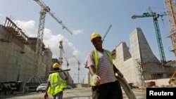 Workers walk at the Panama Canal expansion project site during an organized tour by the Panama Canal authorities in Panama City, Feb. 21, 2014. 