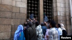 People gather as workers distribute free food for the needy from inside a mosque, during the Muslim fasting month of Ramadan in Cairo, July 10, 2013. 