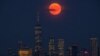 The full moon rises above the New York City skyline on the 50th anniversary of the Apollo 11 moon launch, Tuesday, July 16, 2019. (AP Photo/J. David Ake)
