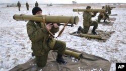 FILE- Ukrainian soldiers perform weapons exercise at training ground outside Lviv, western Ukraine, Feb. 5, 2015.