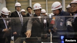 ປະທານ Thein Sein (ກາງ) ໄປເບິ່ງໂຮງໄຟຟ້າ ພະລັງນໍ້າຮ້ອນ Kawasaki ຂອງບໍລິສັດໄຟຟ້າ Tokyo Electric Power Company (TEPCO) ທາງກໍ້າໃຕ້ຂອງນະຄອນຫລວງໂຕກຽວ ເມື່ອວັນທີ 22 ເມສາ 2012. 