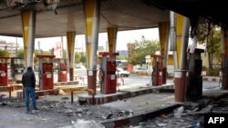 An Iranian man checks a scorched gas station that was set ablaze by protesters during a demonstration against a rise in gasoline prices in Eslamshahr, near the Iranian capital of Tehran, on November 17, 2019.